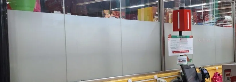 Vinilo ácido aplicado en cristalera de supermercado como franja de privacidad y señalización